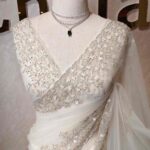 Net saree with intricate floral embroidery along the border