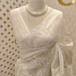 Organza with floral and leafy applique work and golden buttas on blouse