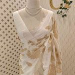 Linen saree with roses like flowers and leafs motif on the body along with scalloped boarder