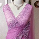 Net saree with a combination of floral sequin motifs and delicate beadwork, often with a decorative scalloped border