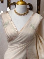Tissue silk with thick floral applique embroidery on the pallu and minimal floral motifs allover the body. - Image 11