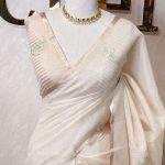 Tissue silk with thick floral applique embroidery on the pallu and minimal floral motifs allover the body.