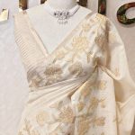 Tissue silk with floral applique embroidery on the lower bottom and pallu and minimal floral buttas allover the body