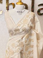 Tissue silk with floral applique embroidery on the lower bottom and pallu and minimal floral buttas allover the body