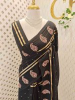 Soft cotton saree with scattered gold buttas, kasavu border, and floral embroidered pallu