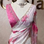 Georgette saree with scattered floral motifs on body decorated with sticky stones and scalloped boarder